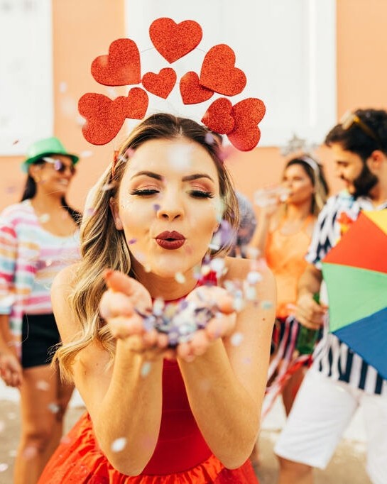 Menina com fantasia de coração curtindo bloco de rua, representando como se preparar para o Carnaval com estilo e conforto