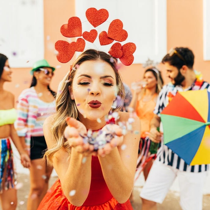 Menina com fantasia de coração curtindo bloco de rua, representando como se preparar para o Carnaval com estilo e conforto