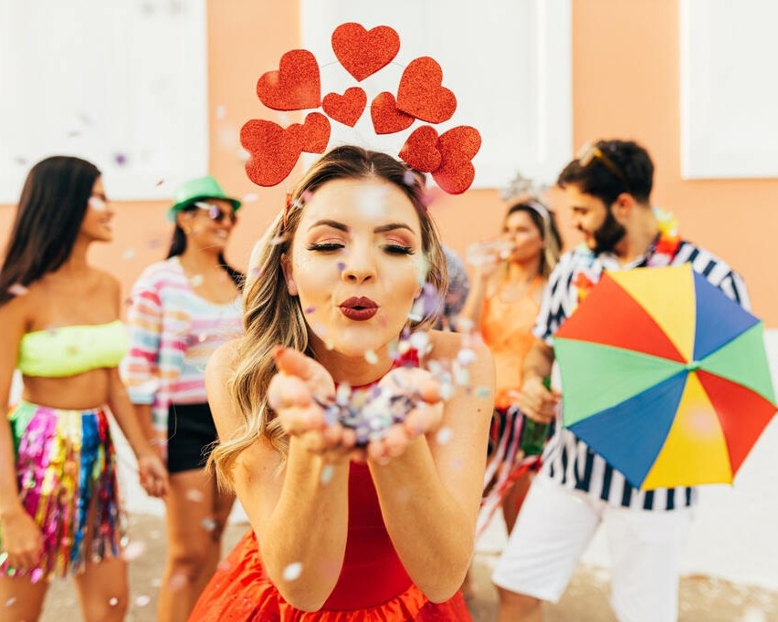 Menina com fantasia de coração curtindo bloco de rua, representando como se preparar para o Carnaval com estilo e conforto