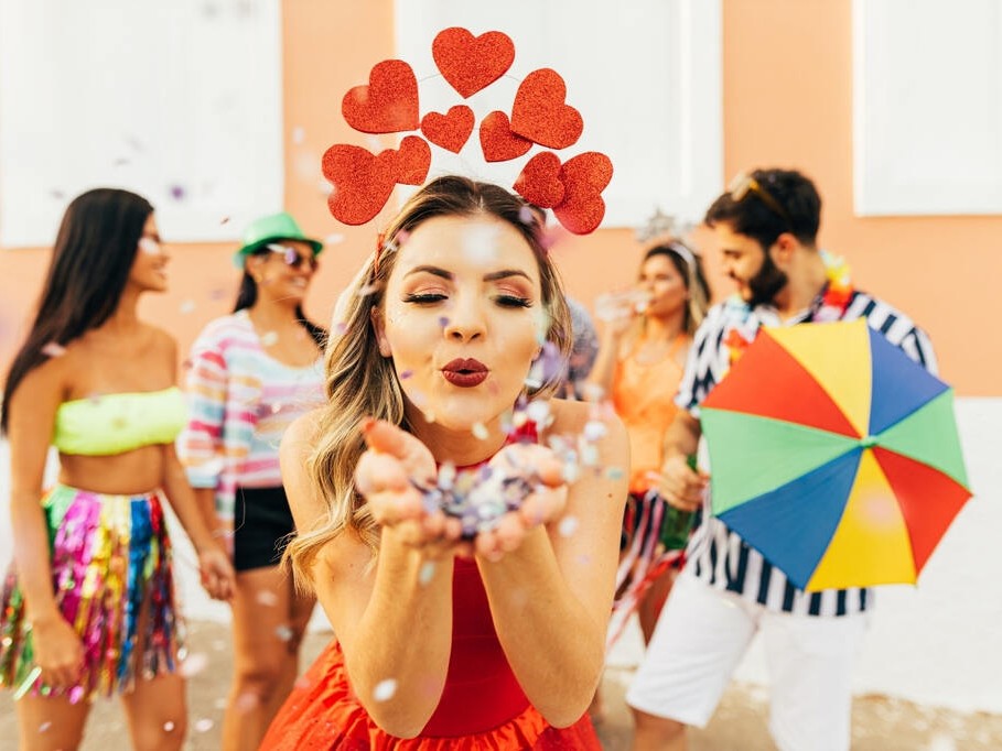 Menina com fantasia de coração curtindo bloco de rua, representando como se preparar para o Carnaval com estilo e conforto