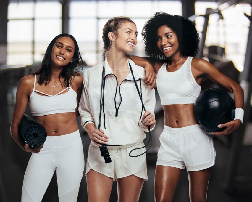 Mulheres usando look fitness feminino na cor branca para academia, com peças confortáveis e funcionais
