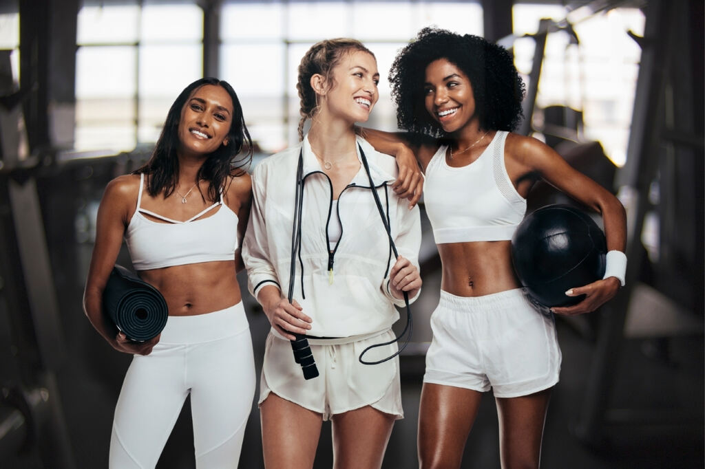 Mulheres usando look fitness feminino na cor branca para academia, com peças confortáveis e funcionais